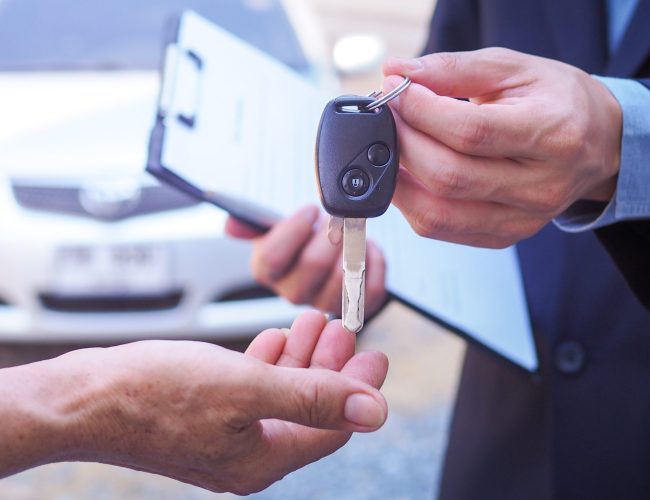 The car salesman and the key to the new owner.